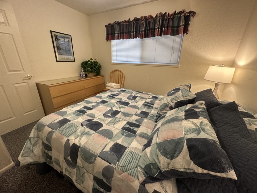 Wide view of downstairs queen bedroom with July 2023 geometric bedding